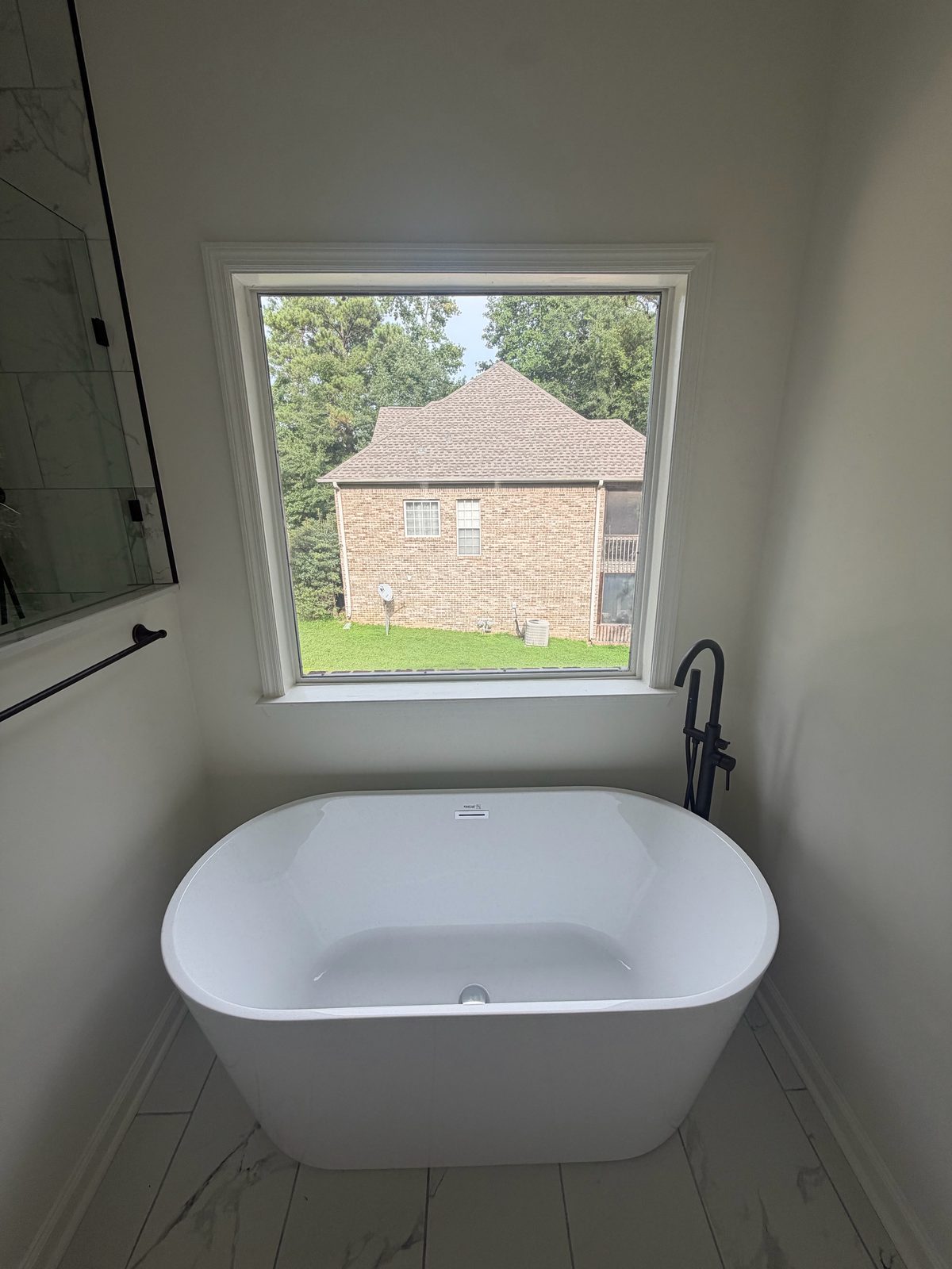 Picture window above a freestanding tub in a newly finished bathroom near Hoover, AL