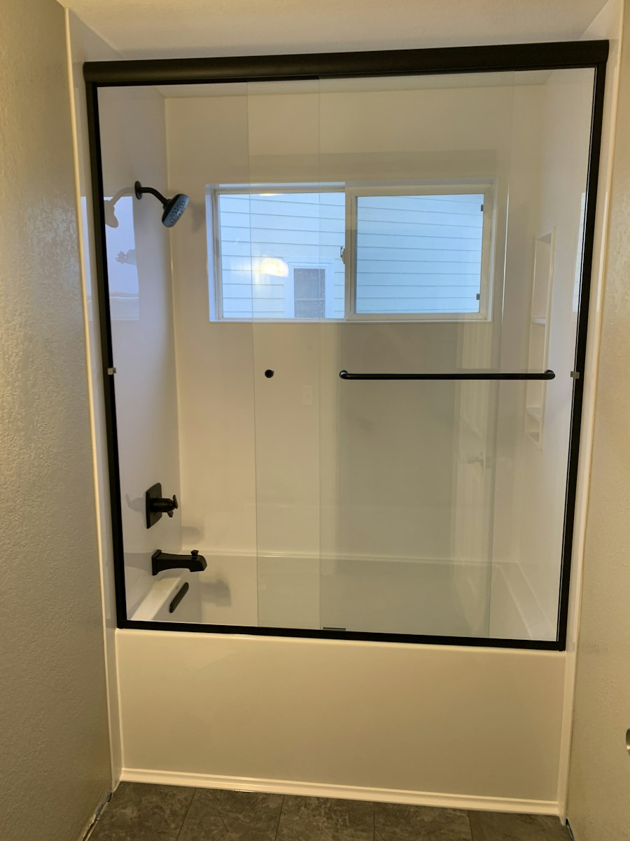 Black-framed sliding glass tub enclosure